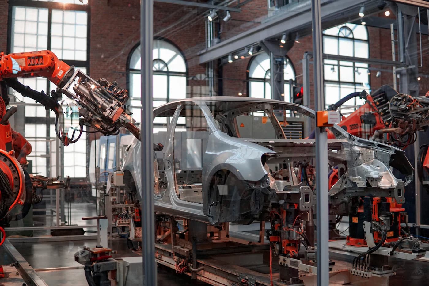 Oranje robotarmen monteren een carrosserie op een productielijn